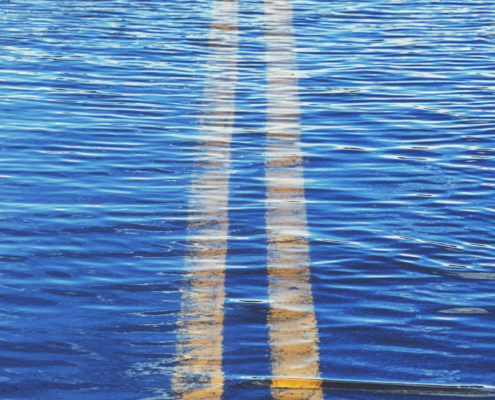 Yellow road lines underwater, giving the illusion of a swimming pool