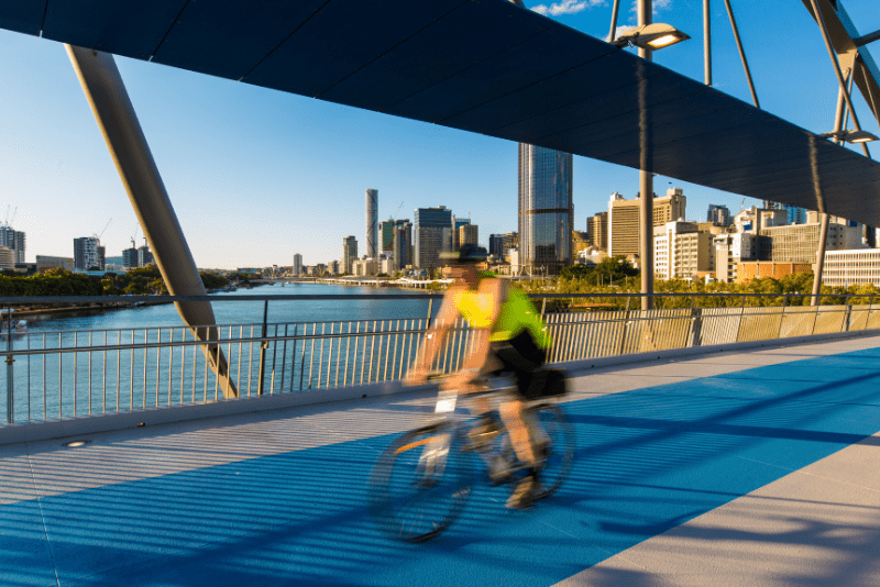 Cyclist riding across a pedestrian bridge in Brisbane